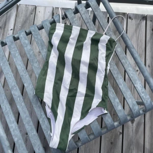 Grön och vit randig baddräkt - Fin randig baddräkt från H&M, använd ett fåtal gånger! Storlek 34.