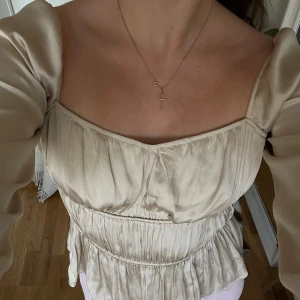 Gullig satinblus H&M - Champagne-färgad långärmad festtopp/blus från H&M.  Använd max 3 ggr = som ny! Klär upp en outfit otroligt fint 🤍  Nypris: 349kr Mitt pris: 80kr