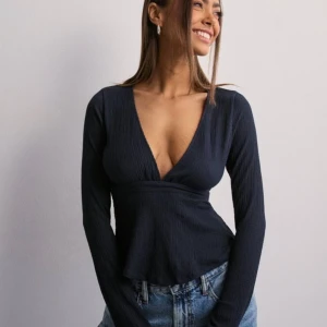 Mörkblå topp från Nelly - En Mörkblå långärmad topp från Nelly, i ny skick, aldrig använd. Ny pris är 299kr.