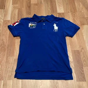 Piké Ralph Lauren - Säljer en blå 💙 pikétröja👕 från Ralph Lauren🏇🏻. Tröjan har en cool detalj med RLYC-märke på ärmen. Passa dig som är ca 158-164. Perfekt för en avslappnad men stilren look ⚜️. Passar både till vardags och fest! 🤝🏼                                                              Hör av er vid minsta fundering 🤔 