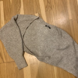 Beige stickad tröja från Gina Tricot - Mysig beige stickad tröja från Gina Tricot i storlek S. Perfekt för kyliga dagar med sin mjuka och varma känsla. Tröjan har en klassisk design med långa ärmar och ribbade detaljer vid ärmslut och nederkant. Passar både till vardags och mysiga hemmakvällar. 🧶✨