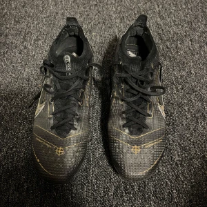 Nike Mercurial Vapor 14 Elite FG - Säljer ett par snygga svarta fotbollsskor med gulddetaljer från Nike i bra skick. Skriv gärna till mig vid frågor eller funderingar!