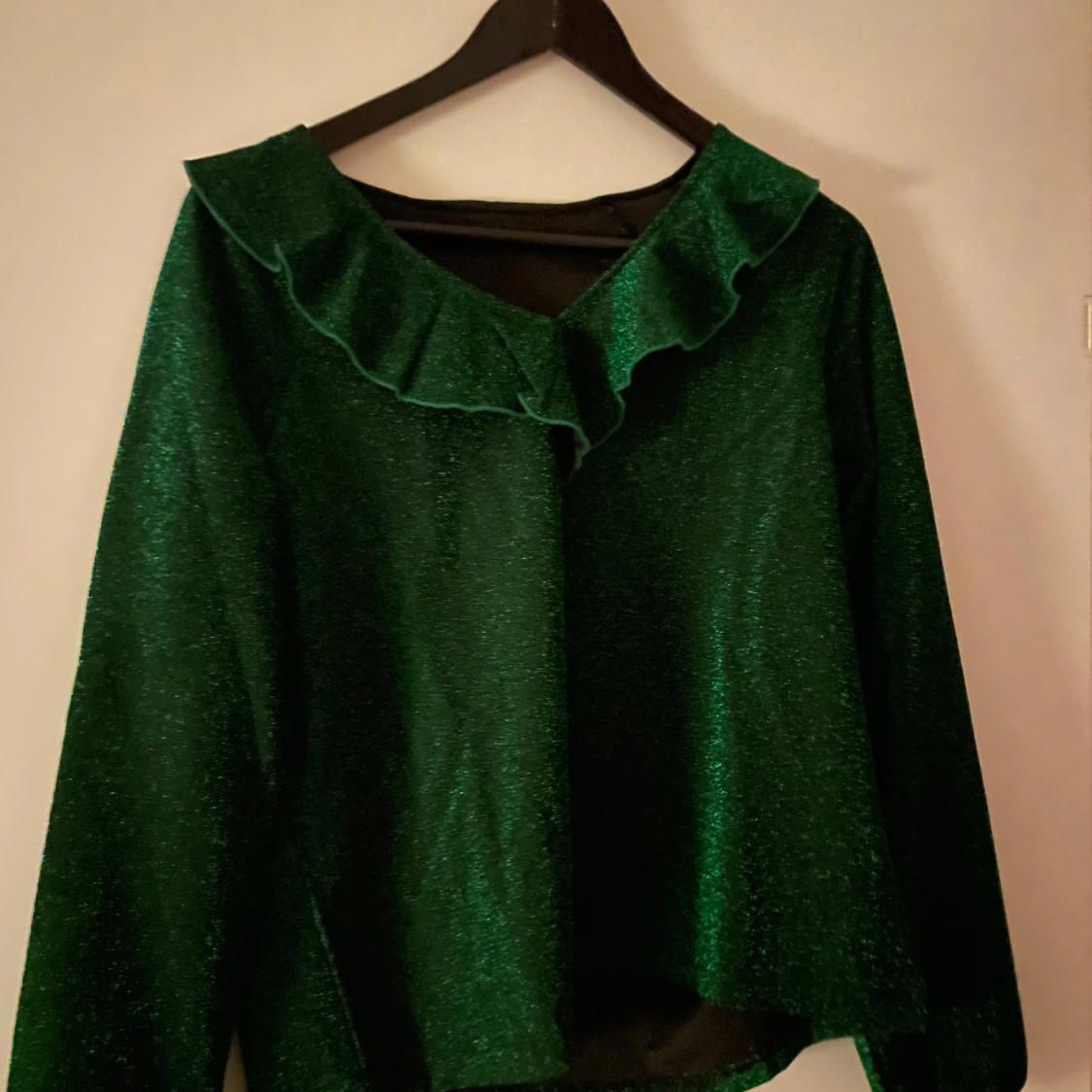 Grön glittrig tröja med volang
