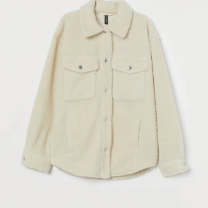 Beige teddyjacka från H&M - Mysig beige teddyjacka med knappar framtill och två bröstfickor. Jackan har en avslappnad passform och långa ärmar 💞 säljer då den inte kommer till användning 