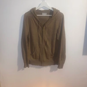Beige hoodie från Davida - Säljer en beige kashmirhoodie från davida. 100% Kashmir. Tröjan är beige även om den upplevs brun på bilden (se bild 3 för riktig färg). Storlek M men skulle säga att den passar både S och M.