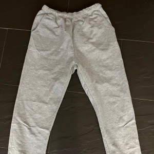Grå mjukisbyxor - Säljer ett par grå mjukisbyxor i bra skick. De är superbekväma och perfekta för chill dagar hemma eller en snabb tur till affären. Byxorna har en elastisk midja och är gjorda av mjukt material. Perfekt för höst och vinter!