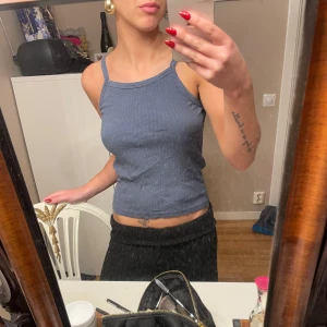 Mörkgrå ribbad linnetopp - Säljer en snygg mörkgrå ribbad linnetopp i mycket bra skick. Toppen är ärmlös med smala axelband och har en tight passform 🤍