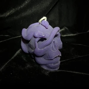 Lila dödskalleljus med ormar - Unikt lila ljus format som en dödskalle med slingrande ormar tillverkat av återanvänt stearin (ljuset har några skador vid tänderna, självklart säljer vi ett nytt helt ljus vid köp)