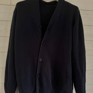 Svart kofta med knappar - Säljer en stilren marinblåa kofta i bra skick. Den har långa ärmar och knäpps med fem knappar framtill. Perfekt för både höst och vinter, och funkar lika bra till vardags som till fest. Passar till det mesta i garderoben!