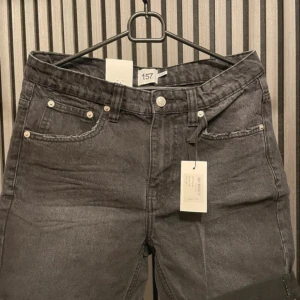 Svart  jeansshorts från 157 - Snygga svart  jeansshorts från 157 i stil Grant. Perfekta för sommaren med en klassisk femficksdesign och knappgylf. De har en avslappnad passform och är gjorda i slitstarkt denim. Perfekta för en casual look!