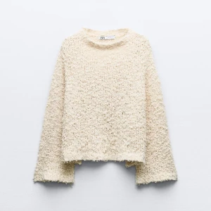 Beige stickad tröja från Zara - Mysig beige stickad tröja från Zara med en fluffig textur. Tröjan har långa ärmar och en avslappnad passform, perfekt för kyligare dagar. Enkel och stilren design som passar till det mesta.