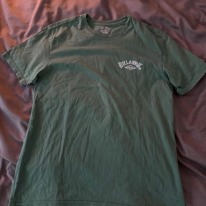 T-shirt från Billabong - Säljer en grön t-shirt från Billabong med tryck både fram och bak. T-shirten är i väldigt bra skick och bara använts några gånger.