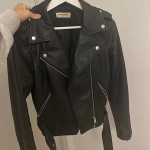 Svart skinnjacka från Glamorous - Snygg svart skinnjacka från Glamorous med dragkedjor och knappar. 