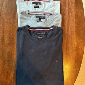 T-shirts från Tommy Hilfiger - Säljer tre stilrena t-shirtar från Tommy Hilfiger i olika färger: marinblå, ljusblå och vit. De är tillverkade i kvalitativ bomull och är sparsamt använda. Storlek L men små i storleken. Passar för runt 170-180. Kan säljas separat också. 