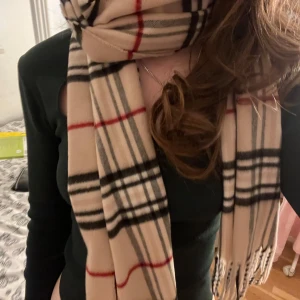 Burberry liknande halsduk - Säljer denna jättefina burberry liknande halsduk eftersom den inte kommer till användning. Den är i superfint skick och endast använd ett fåtal gånger, passar perfekt på höst eller vinter. Skriv gärna för fler bilder eller andra frågor!💘