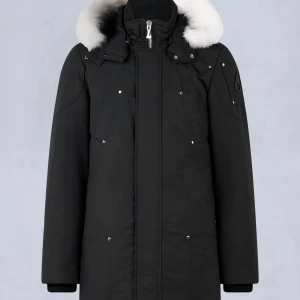 Svart parkajacka med pälsdetalj moose knuckles - Snygg svart parkajacka från Moose Knuckles med vit pälsdetalj på huvan. Jackan har en stilren design med dragkedja och knappar framtill. Perfekt för kalla vinterdagar.