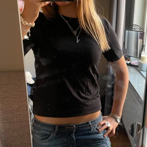 Svart t-shirt - Säljer en klassisk svart t-shirt från Gina Tricot. T-shirten är i ett mjukt bomullsmaterial. Basic och funkar till allt