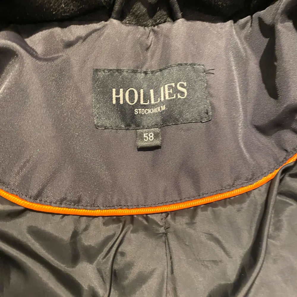 Säljer en svart vinterjacka från Hollies med flera praktiska fickor och dragkedja. Jackan har en hög krage och knappar för extra skydd mot kylan. Perfekt för kalla dagar!. Takit.