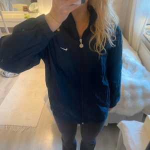 Blå vindjacka från Nike - Säljer en blå vindjacka från Nike. Köptes från vinted men är i jättebra skick! Säljer eftersom den tyvärr inte passade mig. Bilderna är från vinted anonsen men kan skicka egna om det önskas🫶