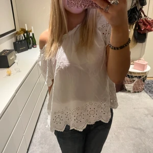 Vit blus - Säljer en söt vit offshoulder blus med broderade detaljer och volangkant. Blusen har en luftig passform och korta ärmar💕