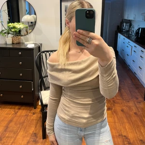 Beige offshoulder topp - Snygg beige offshoulder topp med långa ärmar. Perfekt för en stilren look. Använd en gång! 