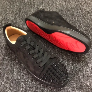 Svarta sneakers med nitar från Christian Louboutin - Snygga svarta sneakers i mocka med nitar på tån från Christian Louboutin. Skorna har en ikonisk röd sula och snörning framtill. Perfekta för att ge en edgy touch till din stil.