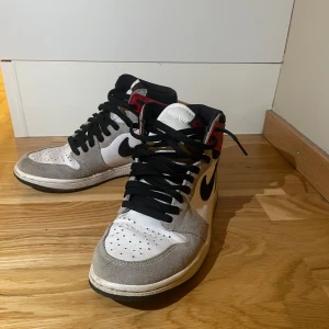 Nike Air Jordan 1 Retro High Light Smoke Grey - Jordan 1 i storlek 41. Skorna är i väldigt bra skick men några små defekter finns