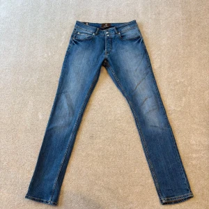 Morris jeans  - Snygga blå jeansbyxor med klassisk femficksdesign och knappgylf. Perfekta för en avslappnad stil. De har en rak passform och är tillverkade i slitstarkt denim.