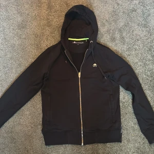 Moose Knuckles hoodie  - Säljer en svart hoodie från Moose Knuckles med dragkedja och huva. Tröjan är äkta och i bra skick. Kvitto finns! Pris kan diskuteras! 