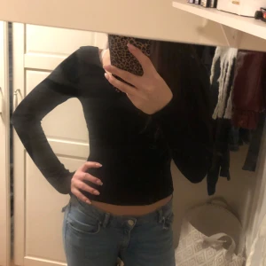 Svart långärmad topp - Säljer en stilren svart långärmad topp med en tight passform. Perfekt för en enkel och snygg look. Toppen är gjord i ett mjukt material som sitter skönt mot kroppen. Djup urringning i ryggen🤍🤍