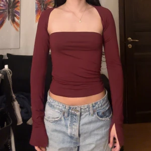 Vinröd topp - Snygg vinröd topp med långa ärmar. Perfekt för en stilren look. Toppen är tight och framhäver figuren på ett elegant sätt.