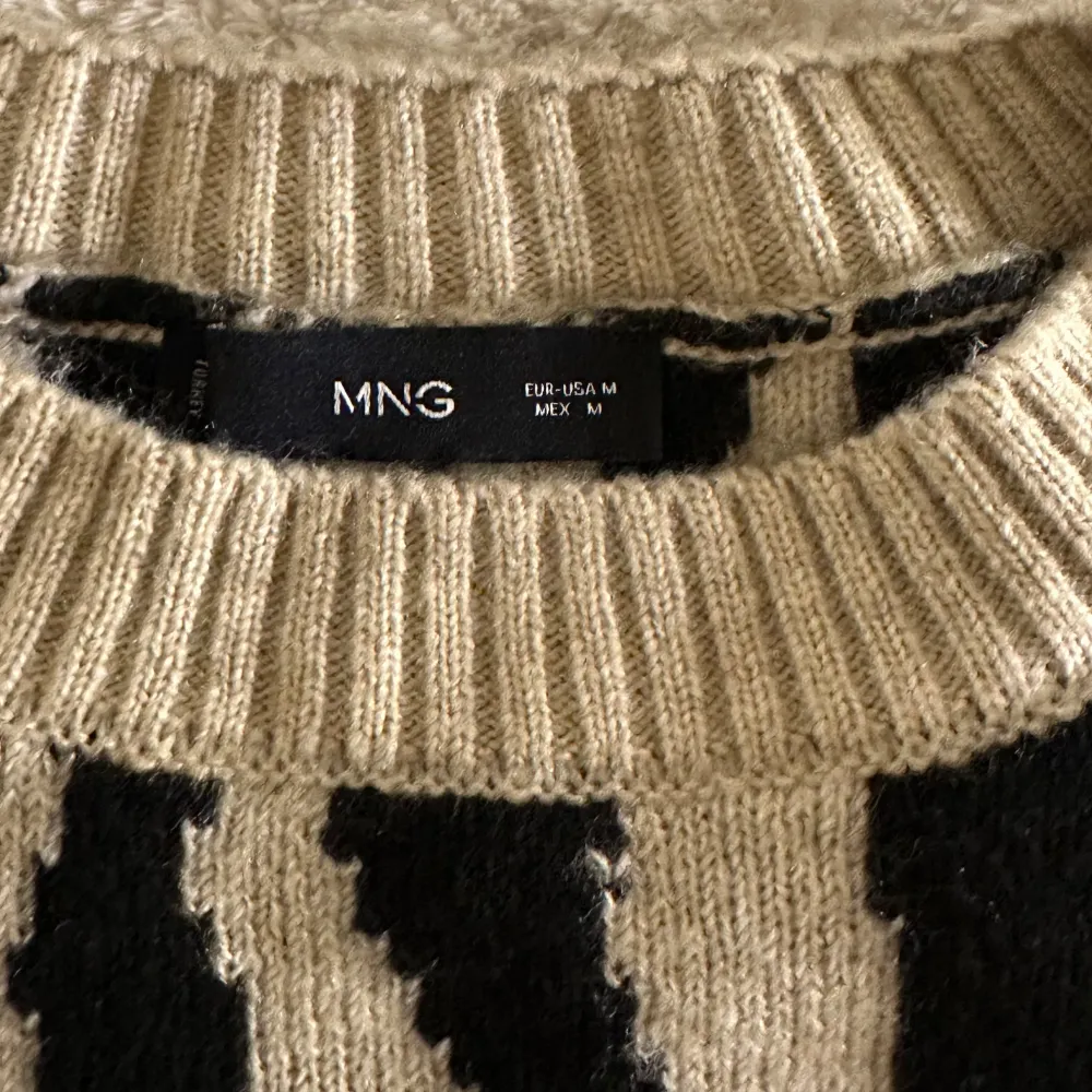 Säljer en cool zebramönstrad tröja från MANGO i beige och svart. Tröjan har långa ärmar och ribbade muddar vid ärmslut och nederkant. Perfekt för att sticka ut i mängden!. Neuletakit & Villapaidat.