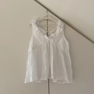 Vit ärmlös topp från Gina Tricot - Jätte fin topp, bra för varma dagar! Väldigt luftig och skön att ha på sig💗 Den var tyvärr för stor för mig😅