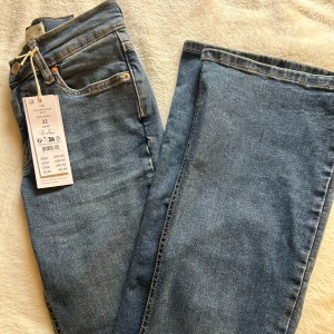 Blå jeans från Gina Tricot  - Helt nya och oanvända bootcut jeans från Gina Tricot. Jeansen är tillverkade i ett stretchigt och bekvämt material som formar sig fint efter kroppen. Köpta för 499kr.