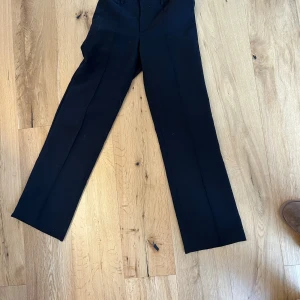 Svarta kostymbyxor från Madlady - Snygga svarta kostymbyxor från Madlady med en klassisk design. Byxorna har en rak passform och är perfekta för en stilren look. De är tillverkade i ett bekvämt material som ger en elegant känsla. Lite knottror, går antagligen bort med roller💕