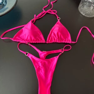 Bikini - Trendig rosa bikini med trekantsöverdel och knytband i sidorna. Perfekt för soliga dagar på stranden eller vid poolen. Den har en enkel men stilren design som ger en snygg look.
