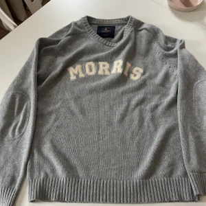 Unik och stilren tröja från Morris  - Säljer en stilren grå tröja från Morris med texten 'MORRIS' i vitt på bröstet. Tröjan är väldigt unik och är exakt det som trender just nu! Perfekt för en avslappnad och snygg look. Tröjan har inga defekter och är precis som ny!Kan sänka priset vid snabb affär! Tröjan passar mer som S/M ‼️