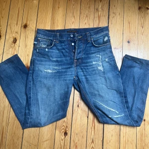 Nudie Jeans Steady Eddie II 30/32 - Ett par Nudie Jeans i ett väldigt bra skick. Modellen är Steady Eddie II ”heavy rain” och har slitningar både bak och fram! Storlek: 30/32 Bara att skriva för frågor🤝