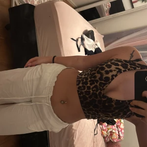 Leopardmönstrad korsettopp - Säljer en snygg leopardmönstrad korsettopp med smala axelband och djup urringning. Perfekt för att ge en vild touch till din outfit. Toppen är i ett stretchigt material som ger en tight passform.