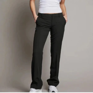 Svarta kostymbyxor från Bik Bok - Snygga svarta kostymbyxor från Bik Bok i en klassisk design. Byxorna har en rak passform och en slit längst ner. Perfekta för en stilren look.