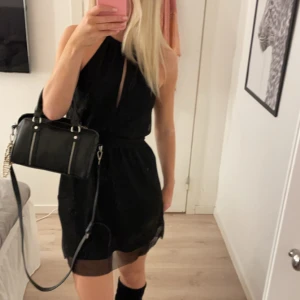 Svart klänning - Snygg svart klänning med öppen rygg. Den är lite glittig. Perfekt för en kväll ute.