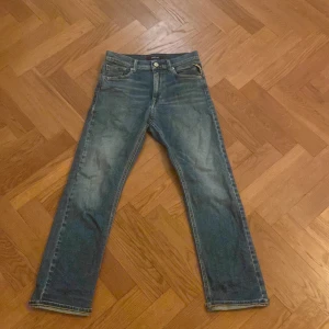 Blå jeans från Replay - Säljer ett par klassiska blå jeans från Replay. De har en straight passform och är tillverkade i slitstarkt denim. Perfekta för en avslappnad stil. Jeansens design inkluderar fem fickor och en knappgylf. Litet lagat hål vi skrevet men syns ej med dem på