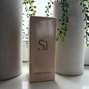 Si Eau de Parfum från Giorgio Armani - Elegant och sofistikerad parfym från Giorgio Armani. Si Eau de Parfum kommer i en stilren, ljusbeige förpackning med svart text. Flaskan innehåller 100 ml av en tidlös doft som kombinerar fruktiga och blommiga noter med en varm bas.