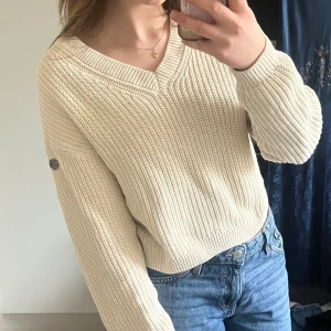 Beige / vit stickad tröja från Pelle P - Säljer en snygg beige stickad tröja från Pelle P. Tröjan har en v-ringad hals och långa ärmar med en knappdetalj på ärmen. Mjukt och luftigt stickat. Passar perfekt till jeans eller kjol 💗