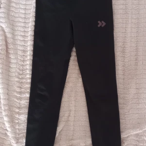 Svarta leggings från 157 - Snygga svarta leggings från 157 med en diskret logga på benet. Midjan är justerbar med en liten innerficka. 