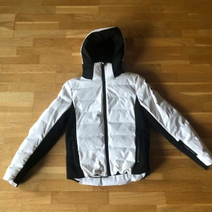 Vit och svart skidjacka från Everest - Snygg vit och svart skidjacka från Everest med snölås och ficka för liftkort. Den är endast använd typ två veckor (då jag åkte skidor), säljer då den blivit för liten. Nypris 1999kr. Skriv gärna om du undrar något eller har prisförslag! 🤗