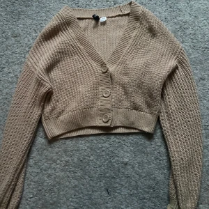Beige stickad kofta - Säljer en söt och trendig kofta! Endast testad så det finns inga tecken på användning! Perfekt till våren