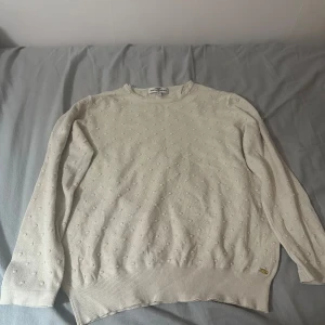 Beige tröja från Hampton Republic - Säljer en stilren beige tröja från Hampton Republic med diskreta prickar. Tröjan har långa ärmar och en rund halsringning. Perfekt för en avslappnad look.