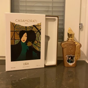 Casamorati Lira Eau de Parfum - Elegant parfym från Casamorati, Lira, i en lyxig flaska med gulddetaljer och en dekorativ tofs. Kolla andra bilden för att se mängd. Full presentation medföljer. Nypris ligger på ca 3000kr hos Kicks