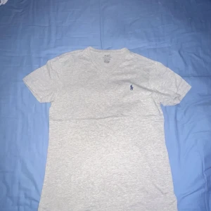 Grå t-shirt från Polo Ralph Lauren - Säljer en stilren grå t-shirt från Polo Ralph Lauren med en liten broderad logga på bröstet. Hör av er vid minsta fråga eller fundering. Pris kan diskuteras